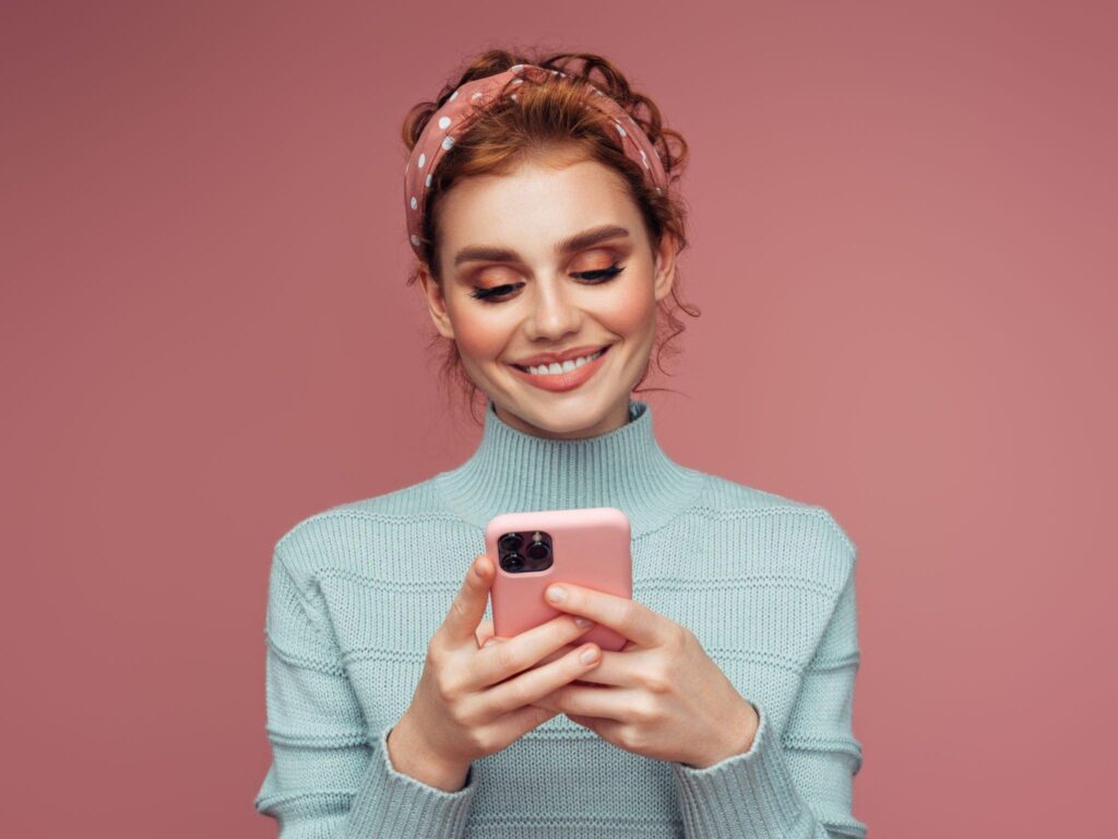 Girl with smiling face holds a iPhone 